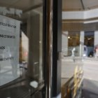 Cartel que indica el cierre temporal en la fachada principal de la clínica dental de Alzira.