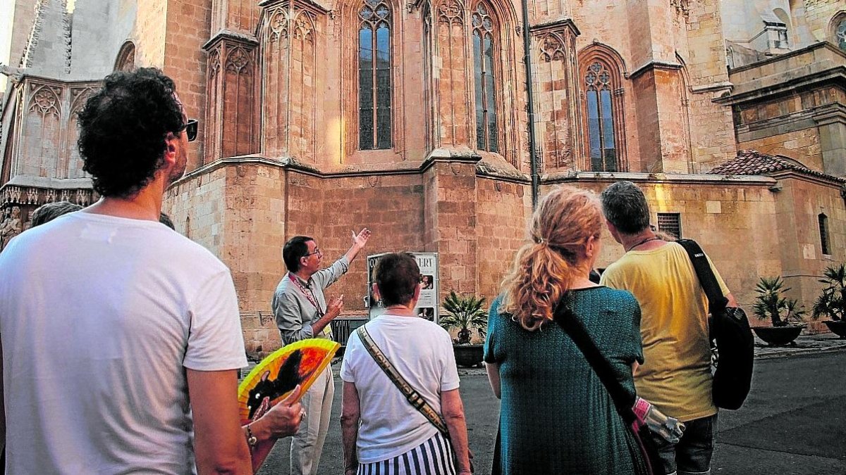 Un grupo de turistas escuchando las explicaciones de la historia de la Catedral de Tarragona.