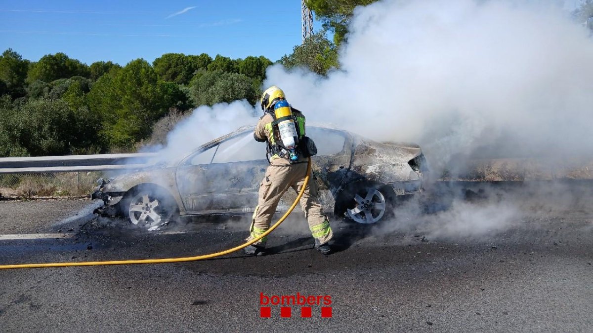 Bombers apagando un turismo que se ha incendiado en L'Ametlla de Mar en la AP-7.​