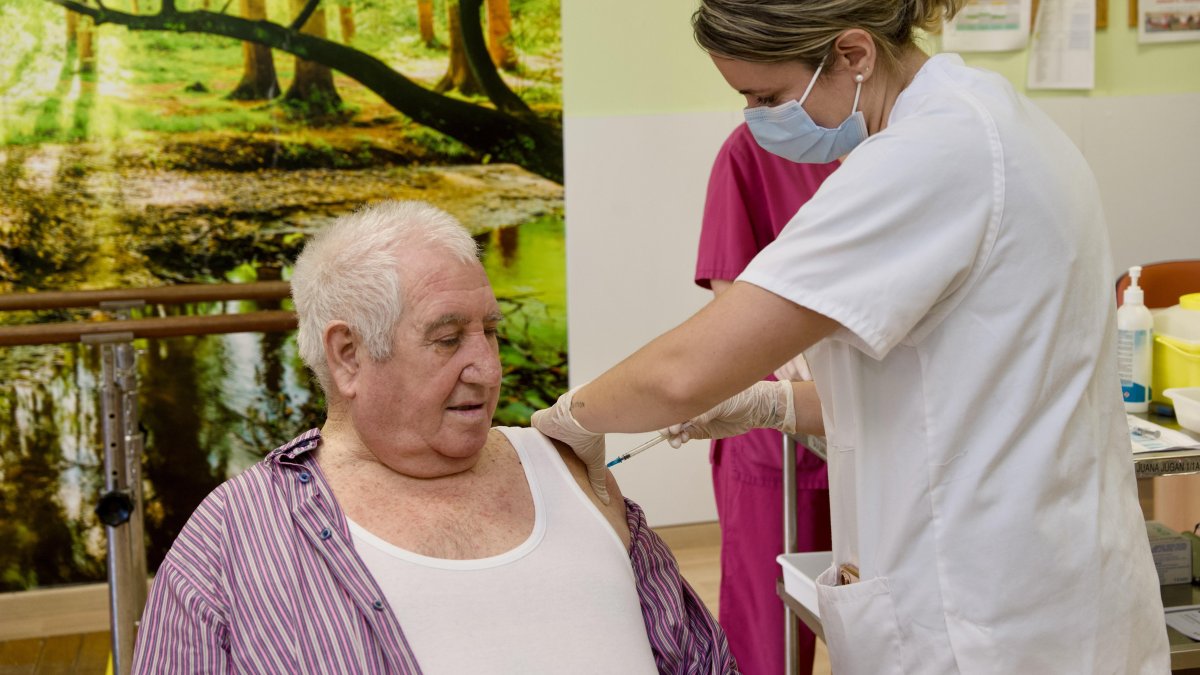 Momento en el que se vacuna a una persona mayor.