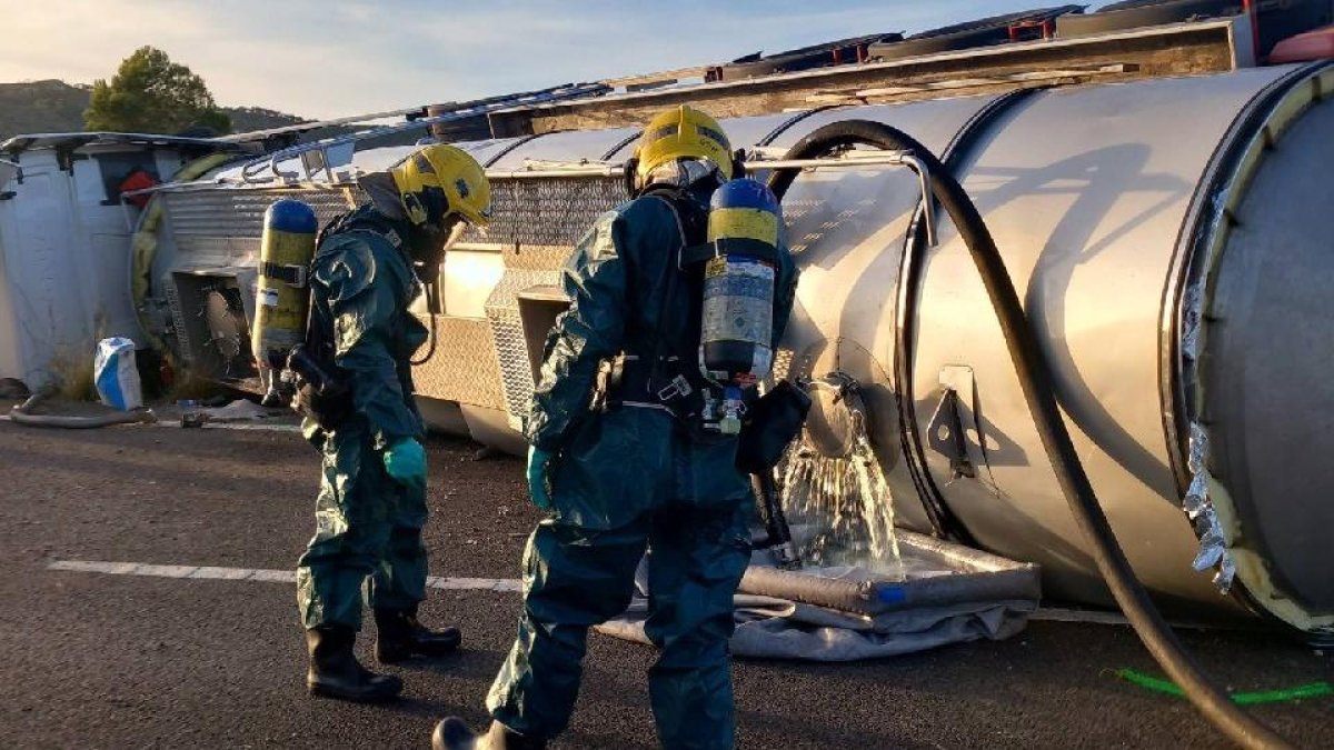 Bombers realizando tareas de transvase del camión cisterna volcado en la AP-7