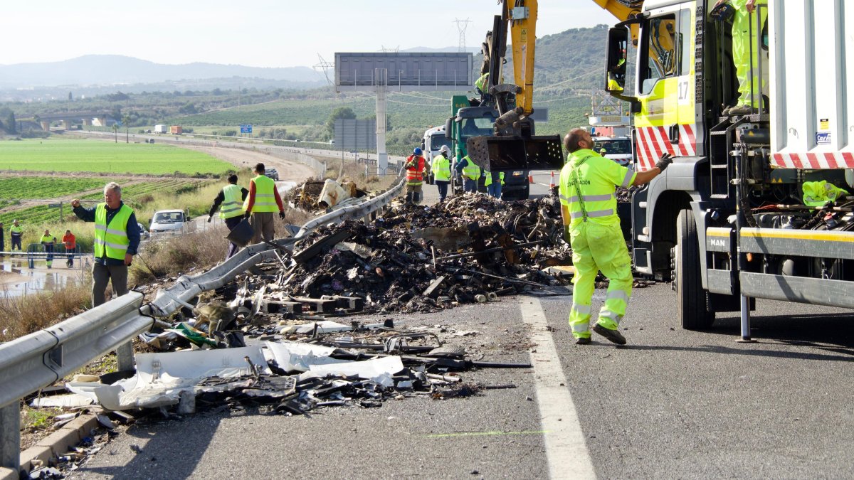 La carga de los tres camiones se ha esparcido por todo el asfalto.