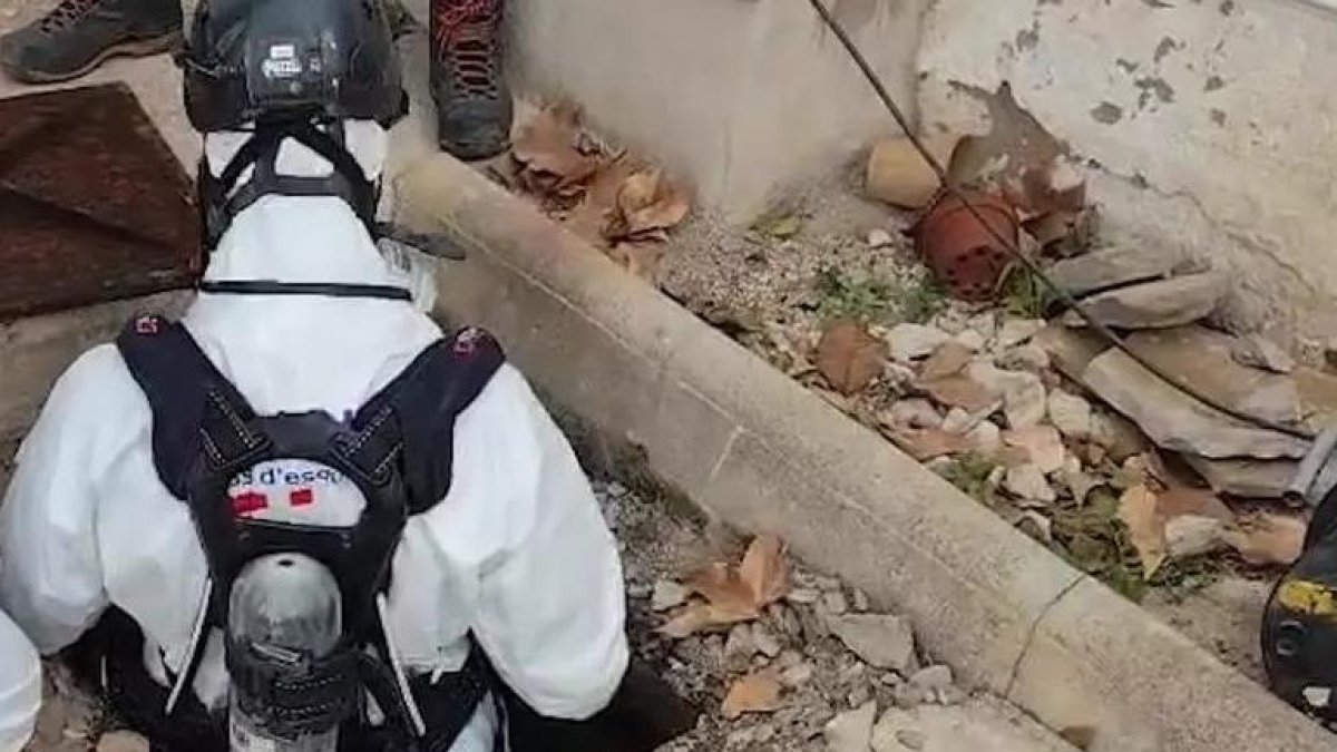 un agente de los mossos descendiendo a la fosa séptica de Sant Jaume dels Domenys.