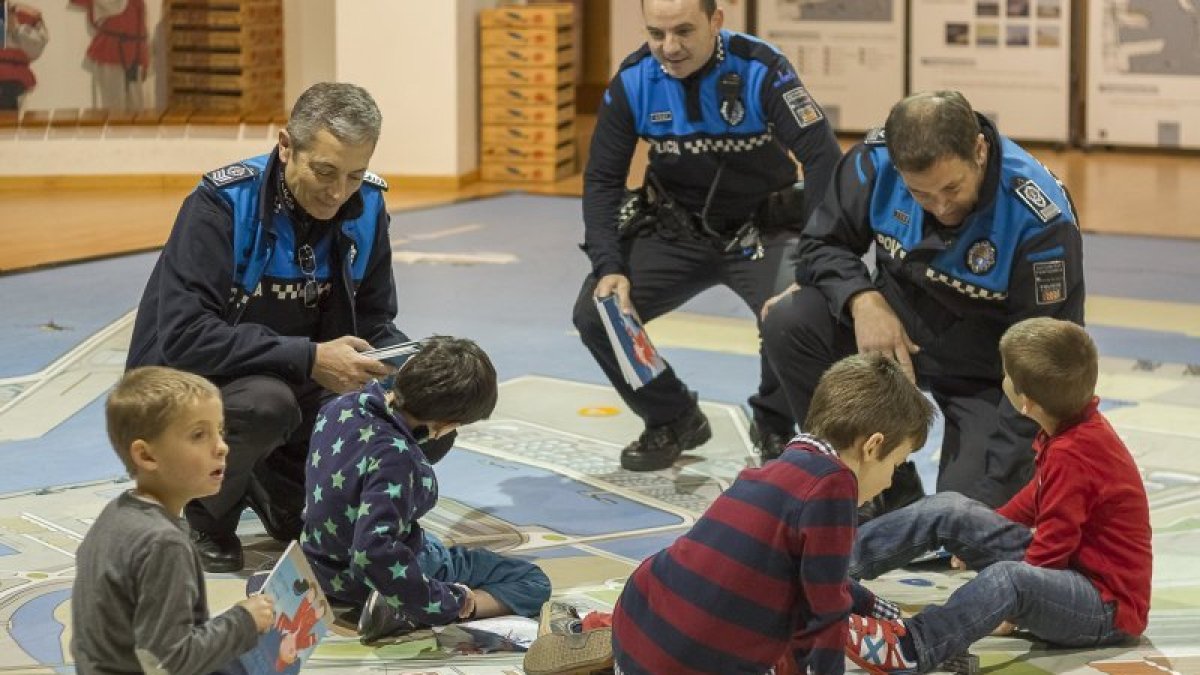 Miembros de la Policía Portuària de Tarragona juegan con niños de Astafanias.