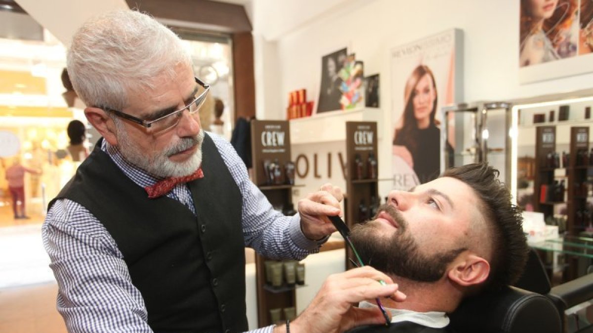 El perruquer Manel Oliva mentre retalla una barba.