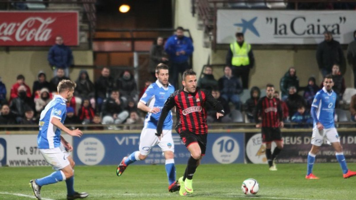 Óscar Rico conduce un balón entre dos rivales durante el partido de ayer.