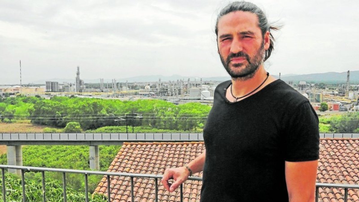 Josep M. Torres (37), antropólogo de formación, ante el paisaje industrial de su pueblo, El Morell. lluís milián