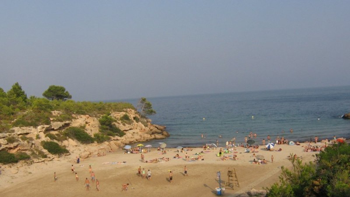 Vista panorámica de la Cala Forn, donde las rocas comparten espacio con la fina y dorada arena.