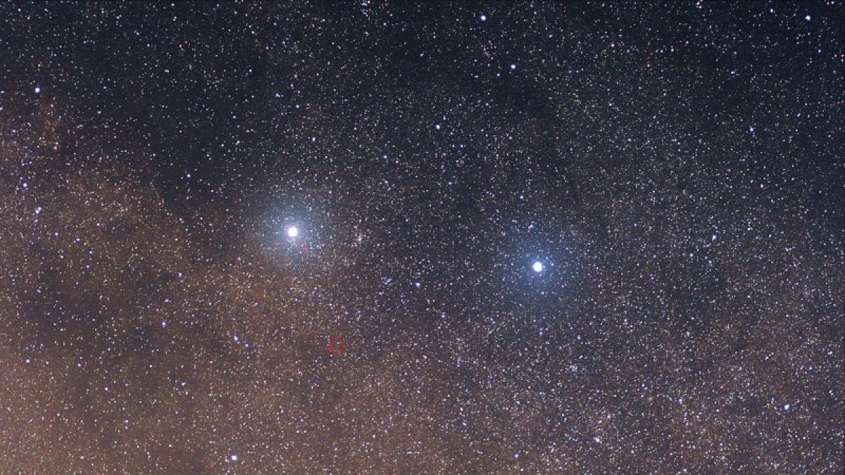La estrella roja débil en el centro del círculo rojo es Próxima Centauri