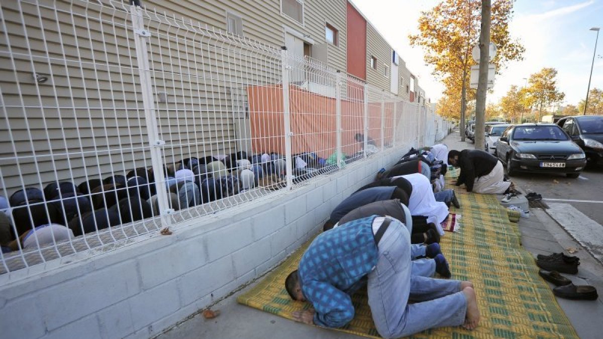 Fieles musulmanes, rezando este viernes al mediodía en la calle, junto a la mezquita de Reus.