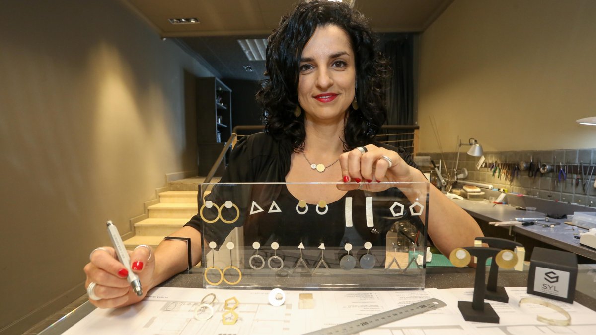 Sandra Yubero, mostrando algunos de las joyas que ha diseñado y planos de arquitectura.