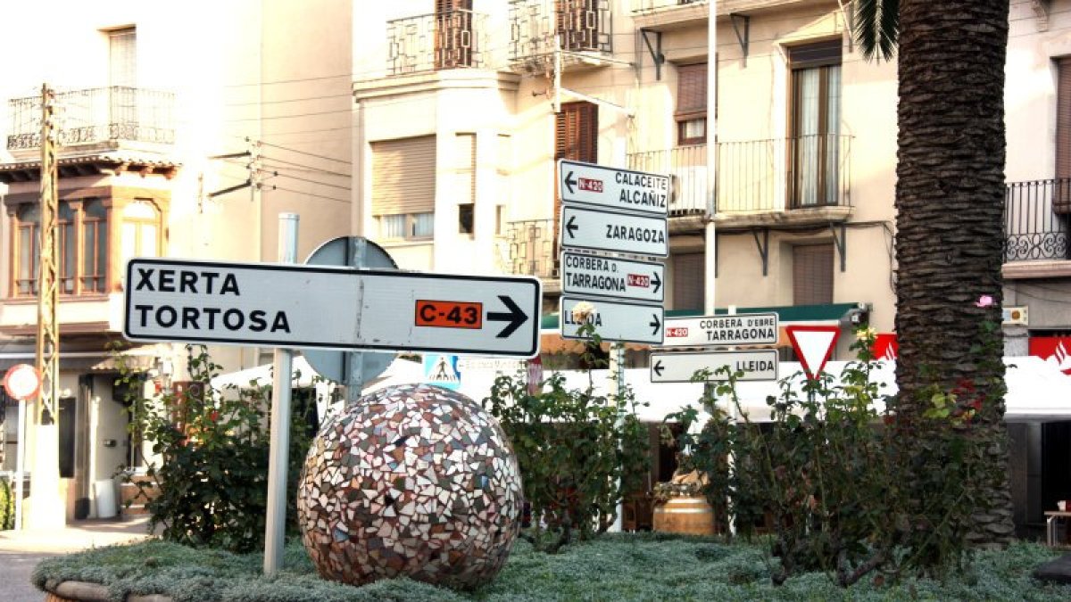 Senyals de trànsit a la plaça de la Farola de Gandesa que marquen la cruïlla entre la N-420 i la C-43 al bell mig de la població.