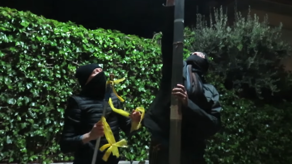 Un grupo de encapuchados con palos y cúteres arrancan lazos amarillos en Vinyols i els Arcs