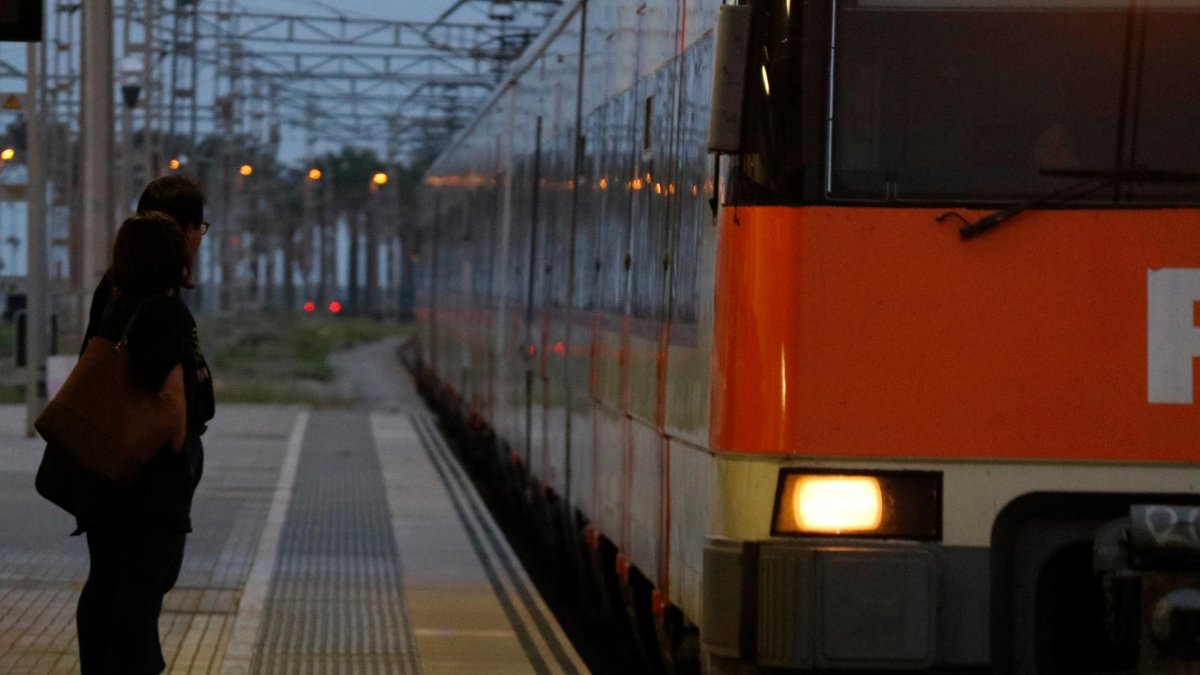 Imagen de archivo de dos pasajeros esperan el tren a la estación de Mataró.