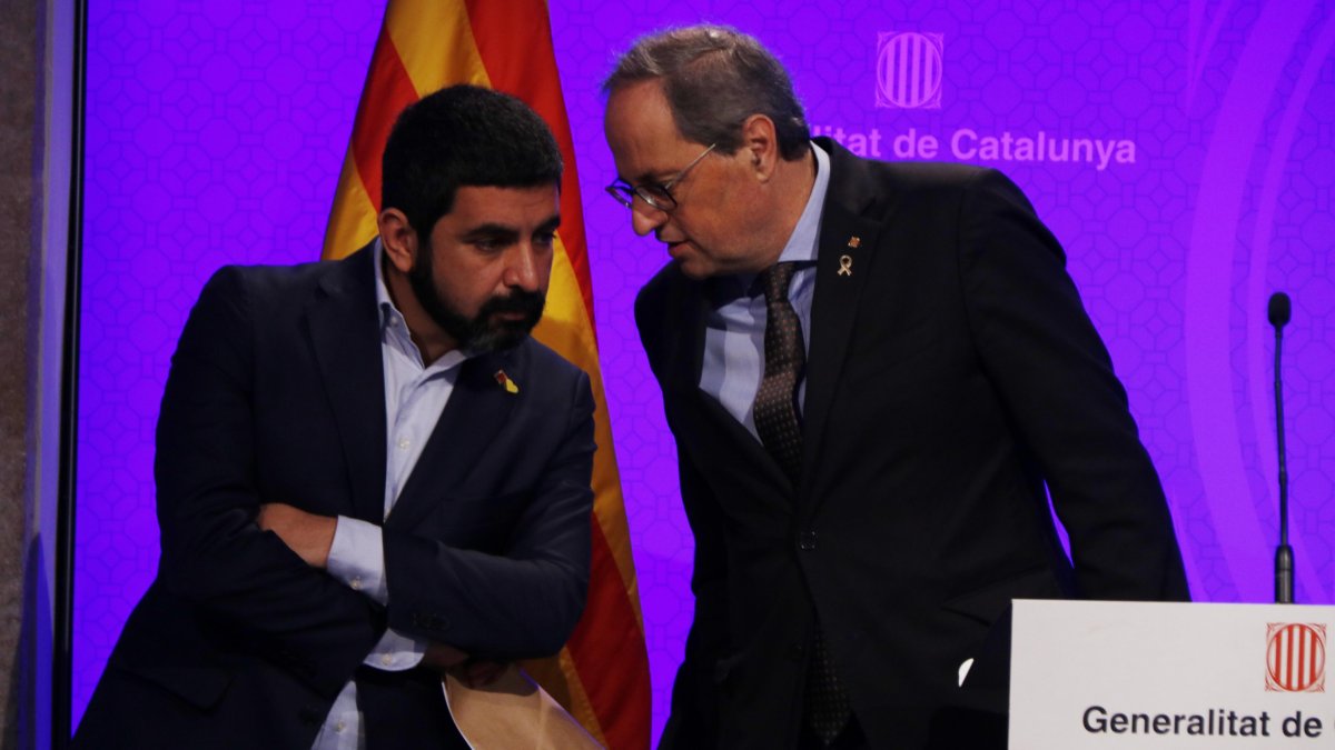 Plan medio del presidente del Gobierno, Quim Torra, hablando con el consejero Chakir El Homrani durante la rueda de prensa por el coronavirus.