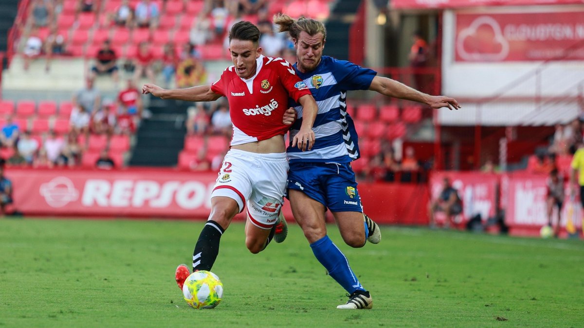 Pol Valentín pugna con el lateral del Llagostera por una pelota en el primer partido de liga.