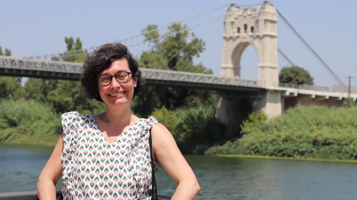 La directora del COMEBE, Teresa Ferré Panisello, amb el pont penjant d’Amposta de fons.