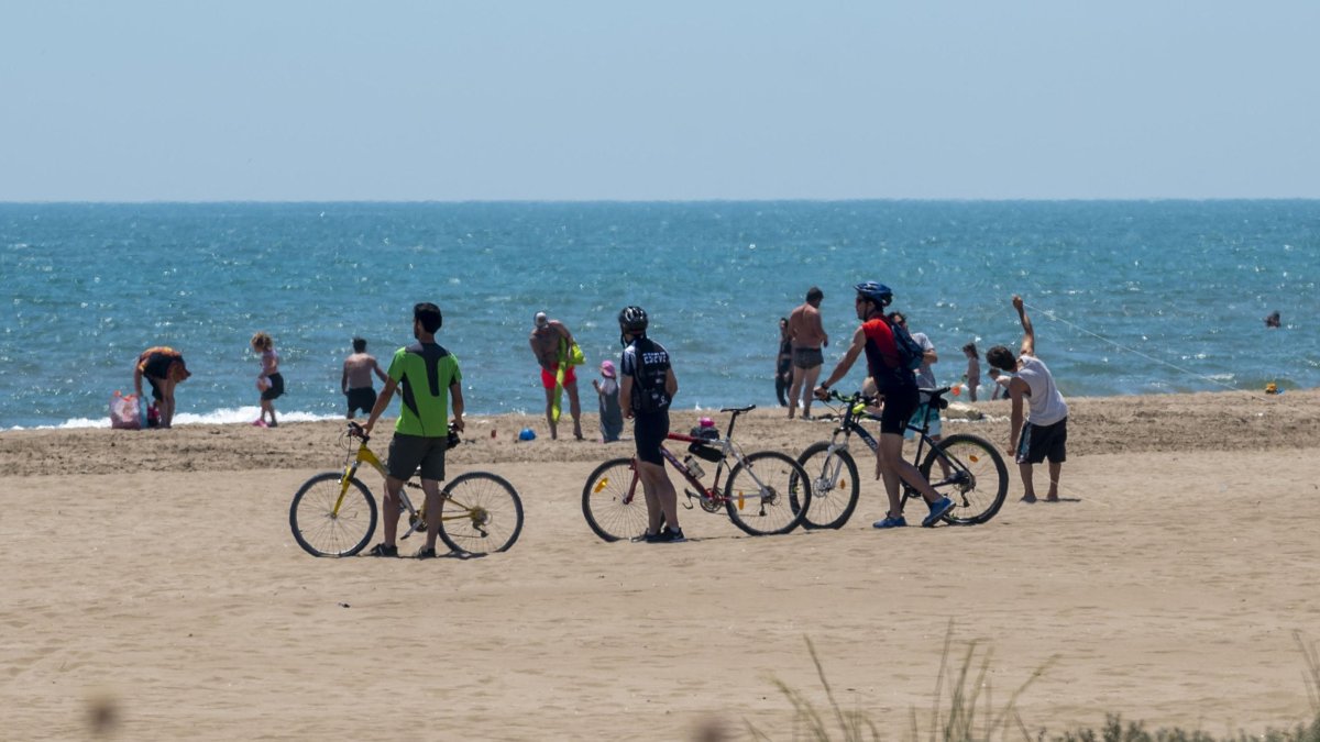 Banyistes i ciclistes al Trabucador, al terme de la Ràpita.