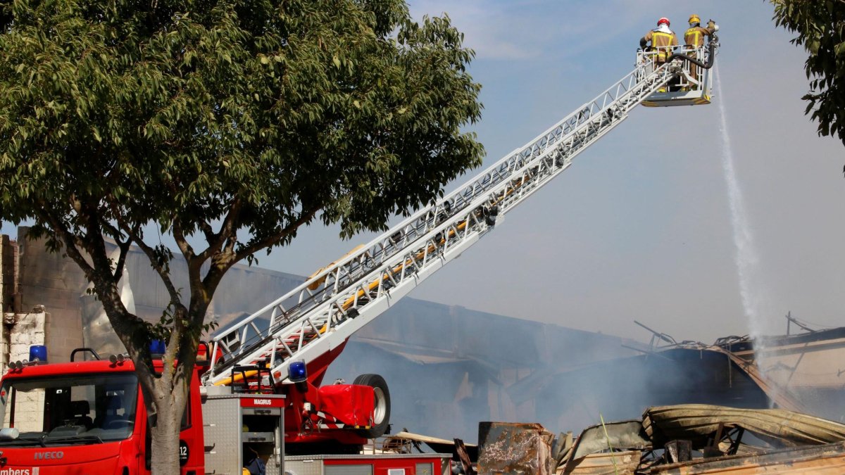 Els Bombers durant les tasques per apagar l'incendi en unes naus de Montblanc.