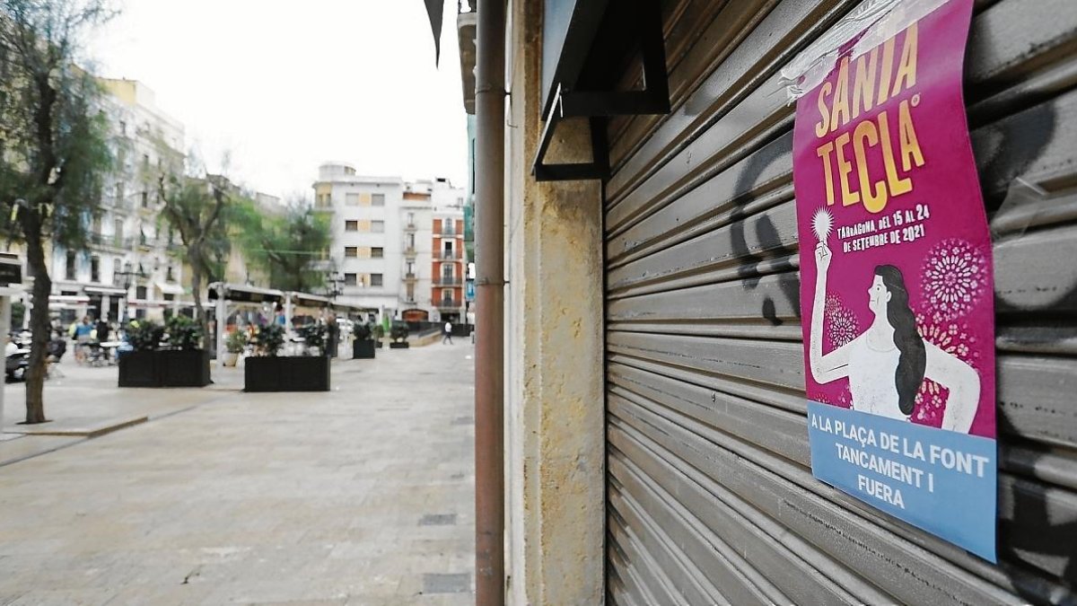 Imagen de ayer, de un local cerrado con un cartel reivindicativo en la Plaça de la Font.