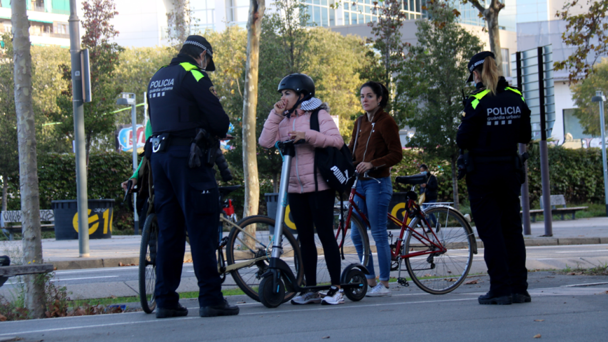 Usuarias de bicicleta y patinete eléctrico durante un control de la URbana de Barcelona.