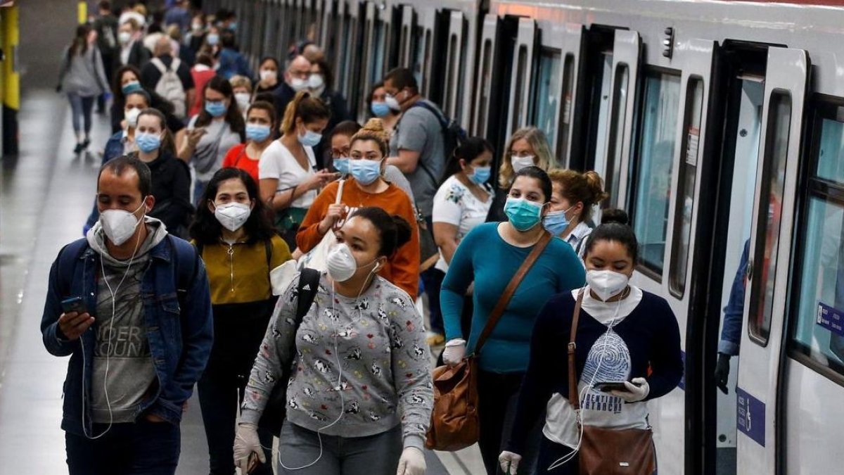 Gente en el metro de Barcelona con mascarilla. EFE