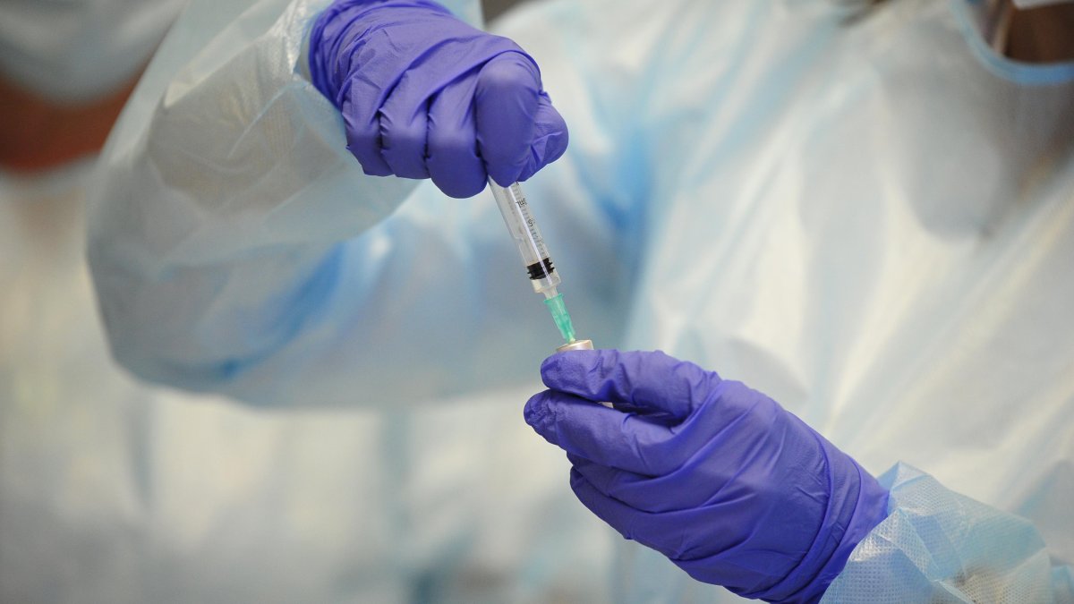 Una persona prepara una dosis de la vacuna.