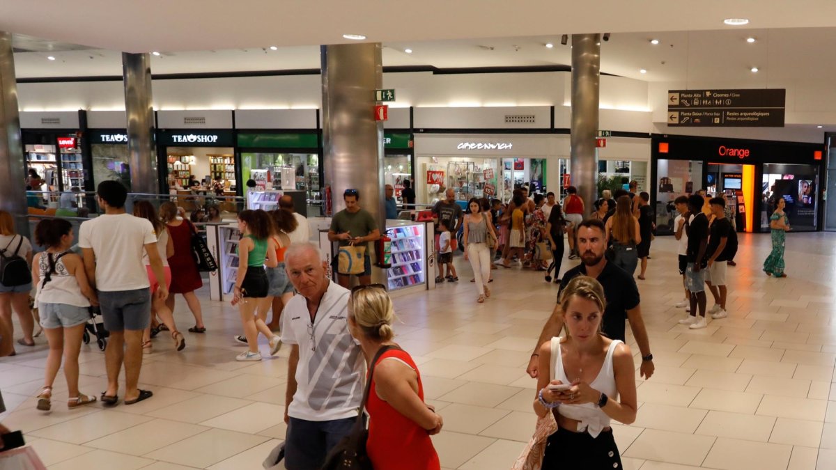 Escaparate de una tienda de Reus, con dos compradores en su interior.
