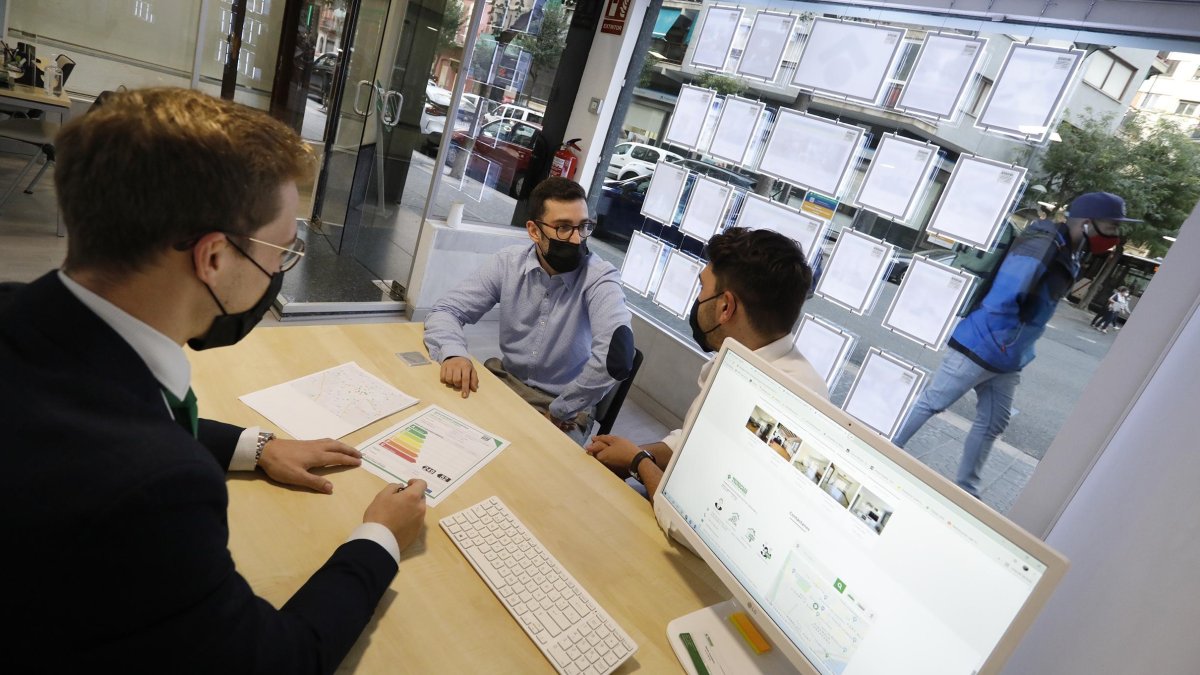 Unos jóvenes visitando una inmobiliaria de Tarragona.