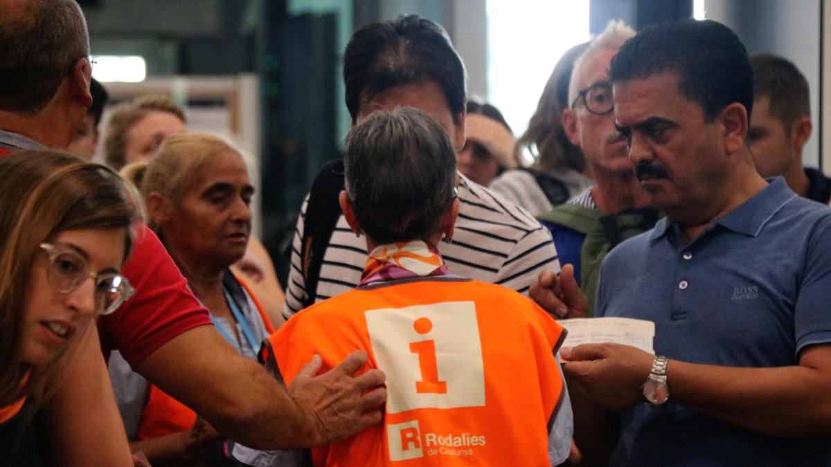 Varios usuarios atendidos por el personal de Renfe, sobre una avería en los trenes.