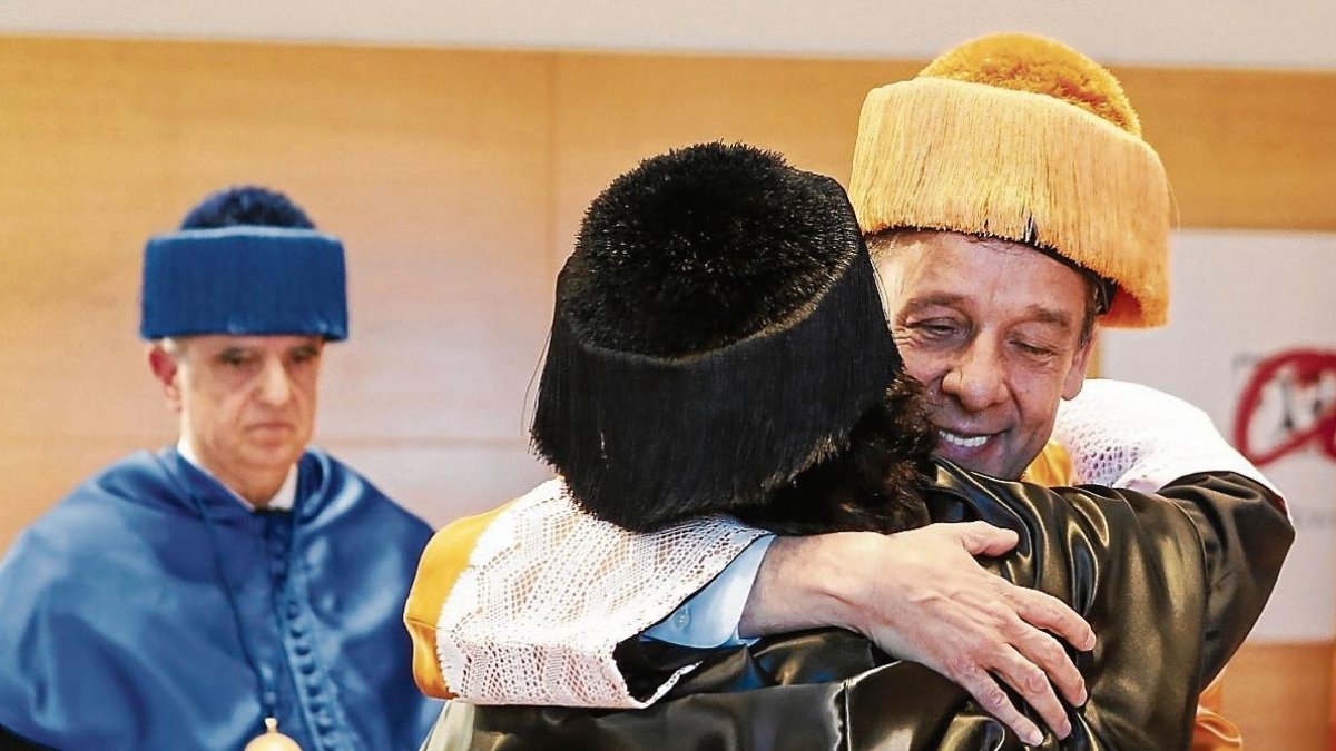 Prats abraza a la rectora Maria José Figueras. A la izquierda el padrino Francesc Xavier Grau.