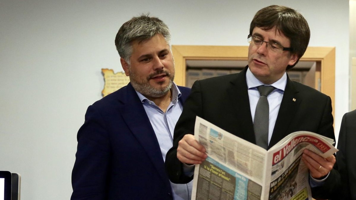 El president Puigdemont ojea un ejemplar de ‘El Vallenc’ junto al alcalde de Valls, Albert Batet.