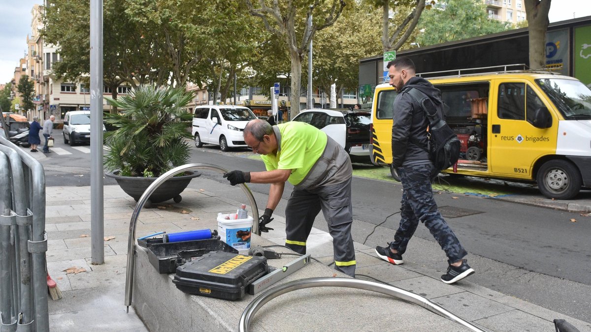 Un operario de las Brigadas Municipales colocando las barandillas esta semana en un banco.