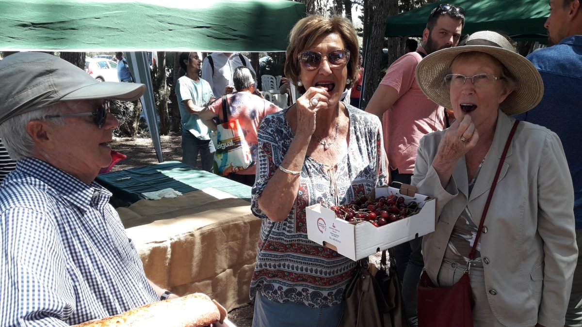 Dues visitants de la fira, degustant les cireres.