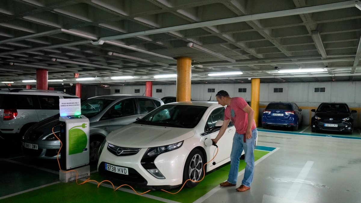 Nicolàs conectando su coche híbrido enchufable en los cargadores del parking de la Llibertat de Reus.
