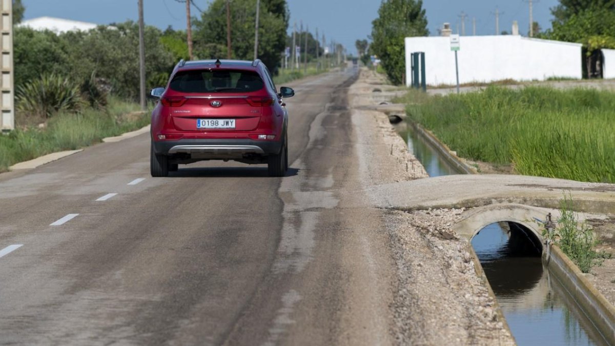 La carretera és estreta i envoltada d’arrossars i pals de llum.