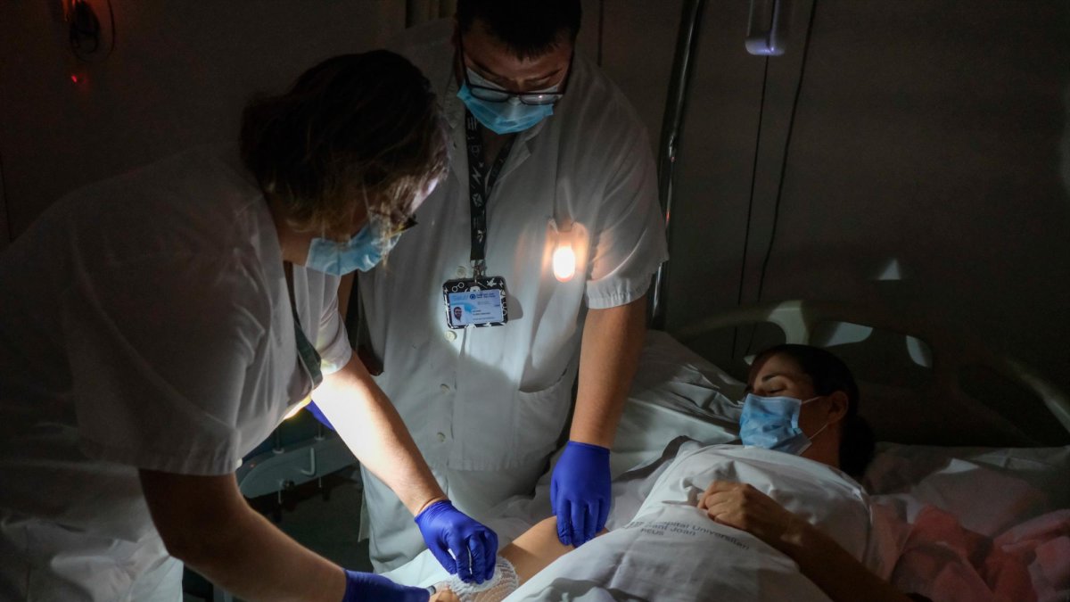 Los profesionales usan linternas para atender a pacientes.