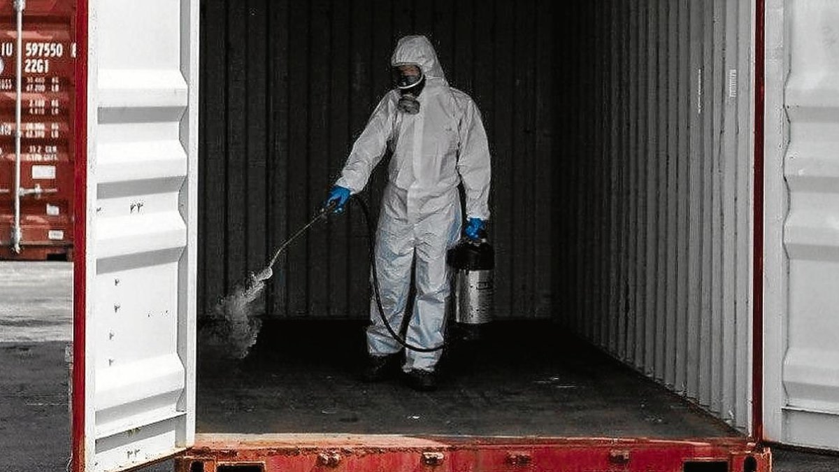 Un trabajador de Roca Defisan desinfecta un contenedor.