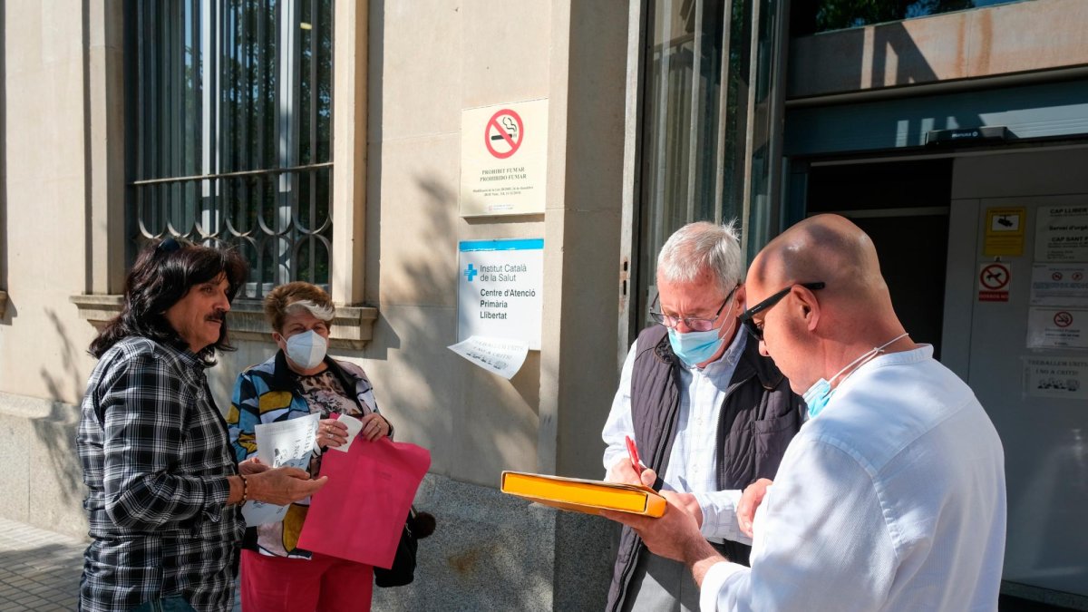 Josep Tutusaus y Josep Ramon Pallejà, ayer, reuniendo apoyos de pacientes, ante al CAP.
