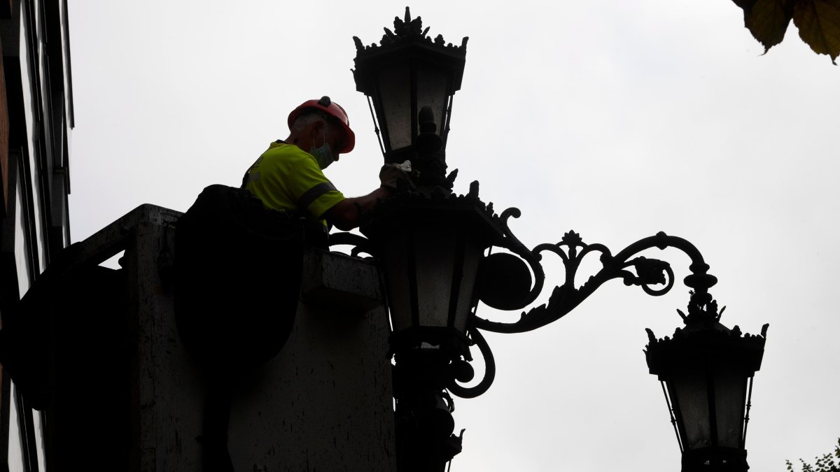 Un operario limpia farolas en el centro de Oviedo, en una imagen de archivo.