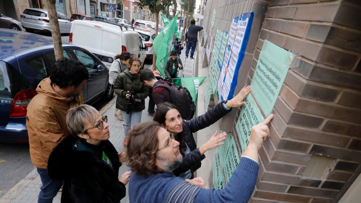 Instante de la pegada de carteles del personal educativo en la fachada de los Serveis Territorials de Educació de Tarragona.