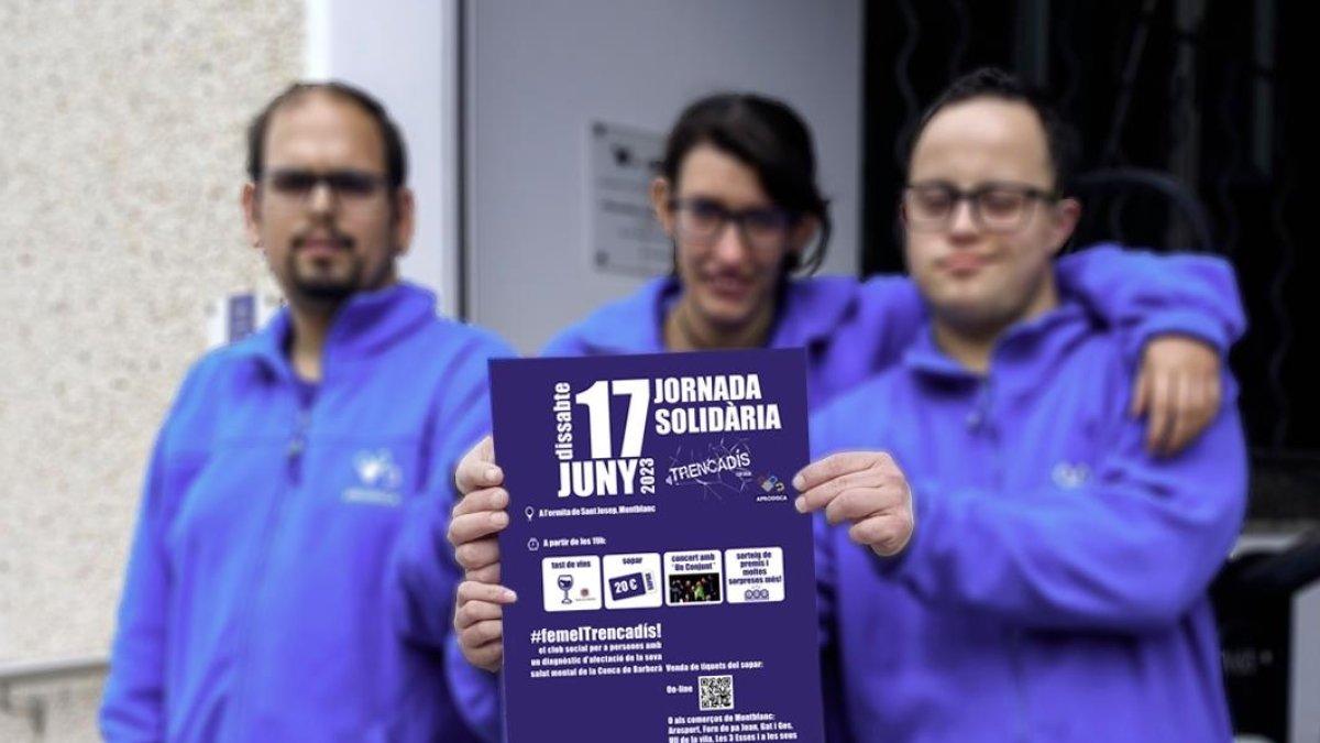 Usuaris d’Aprodisca amb el cartell de la jornada solidària que es farà aquest mes.