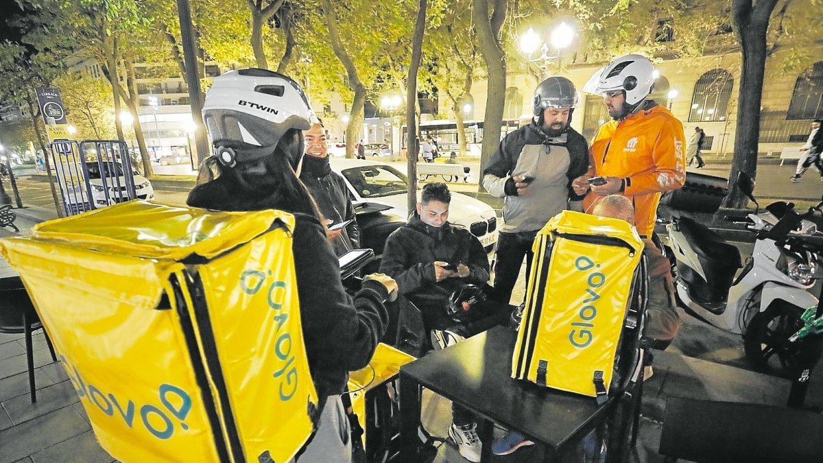 Repartidores esperando pedidos en la Rambla Nova de Tarragona.