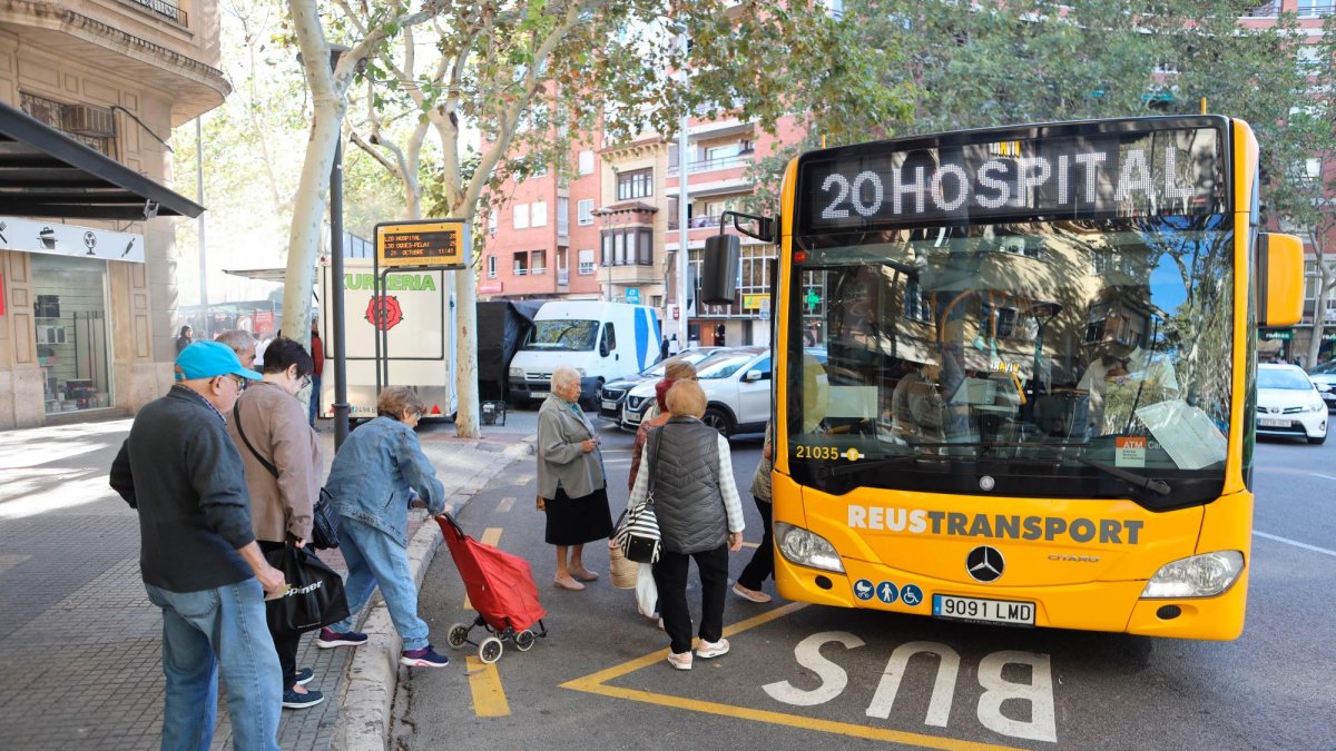Pasajeros subiéndose a un autobús de la L20 de Reus Transport en la plaza de Les Oques.