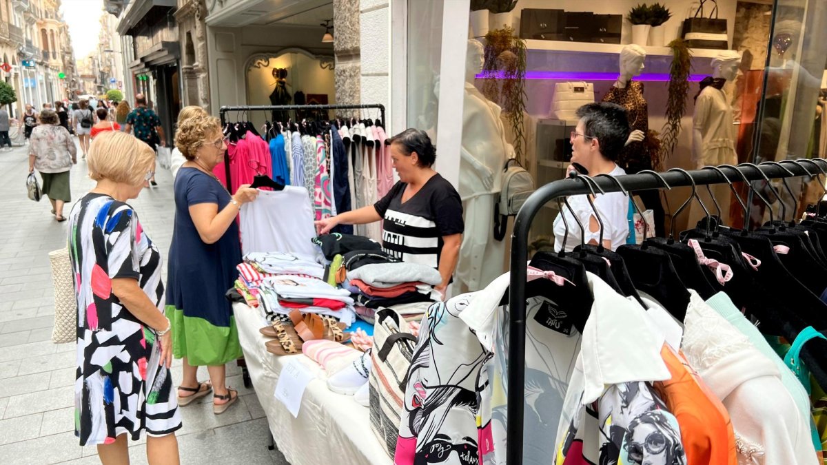 Clientela interesándose por el género de una de las tiendas, en la anterior edición de verano de ‘Les Botigues al Carrer’.