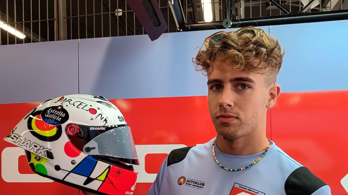 Jeremy Alcoba mostrando su casco en el box de su equipo.