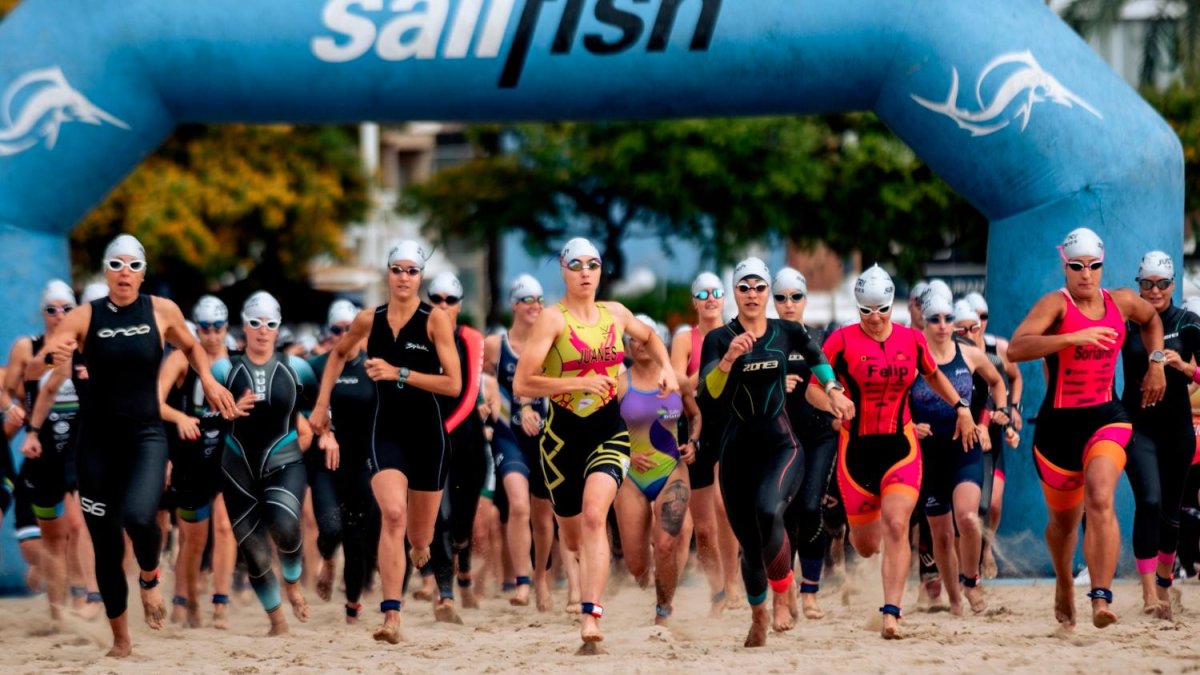 Las participantes femeninas, dirigiéndose hacia el mar para disputar la natación en la playa del Regueral de Cambrils.