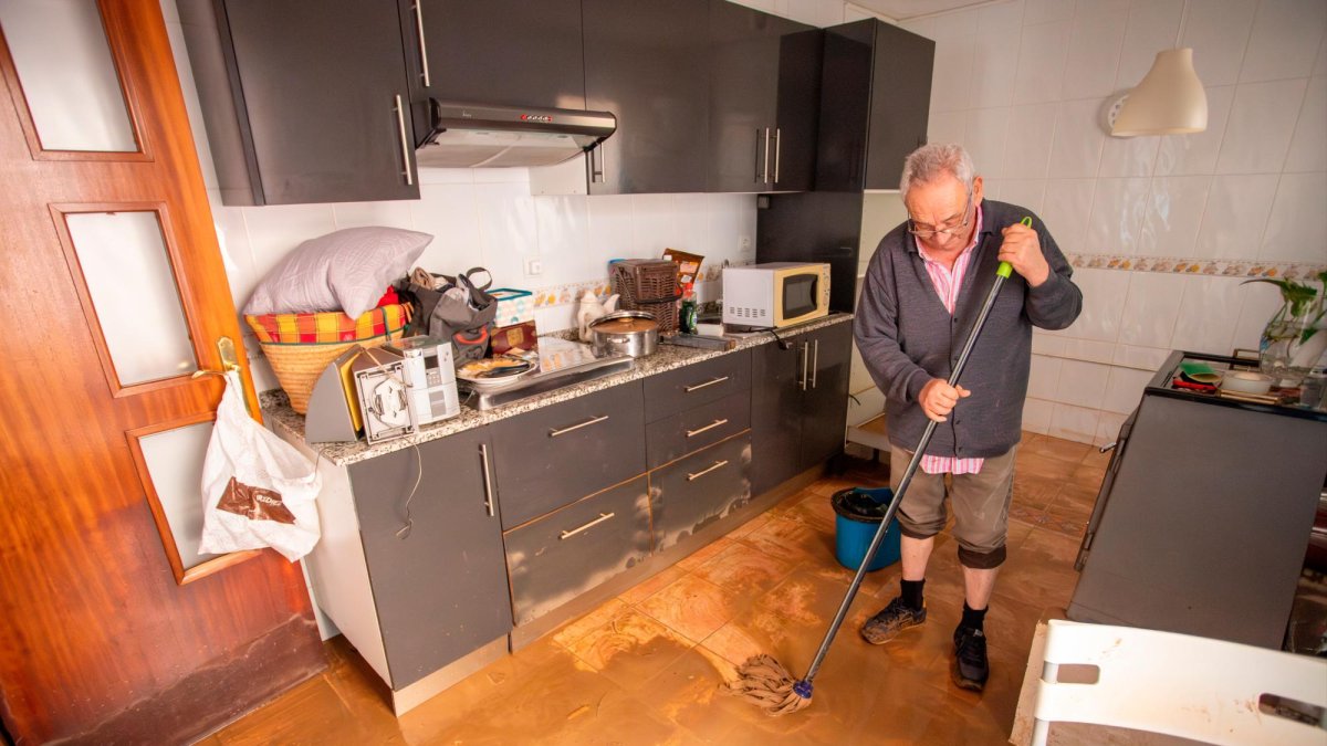Un hombre limpiando la cocina de su chalet en La Móra.