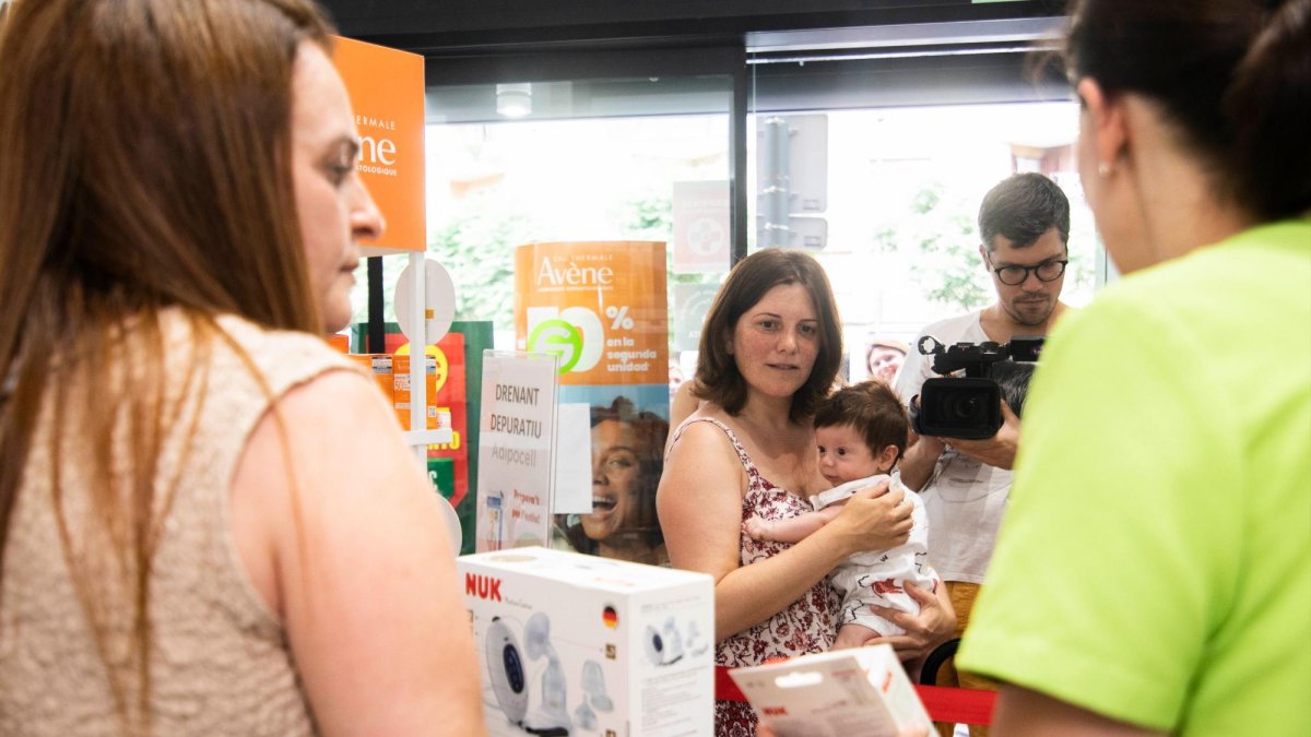 Mireia Alcázar, amb el seu nadó, és atesa en una farmàcia adherida al servei ‘Alletafarma’.