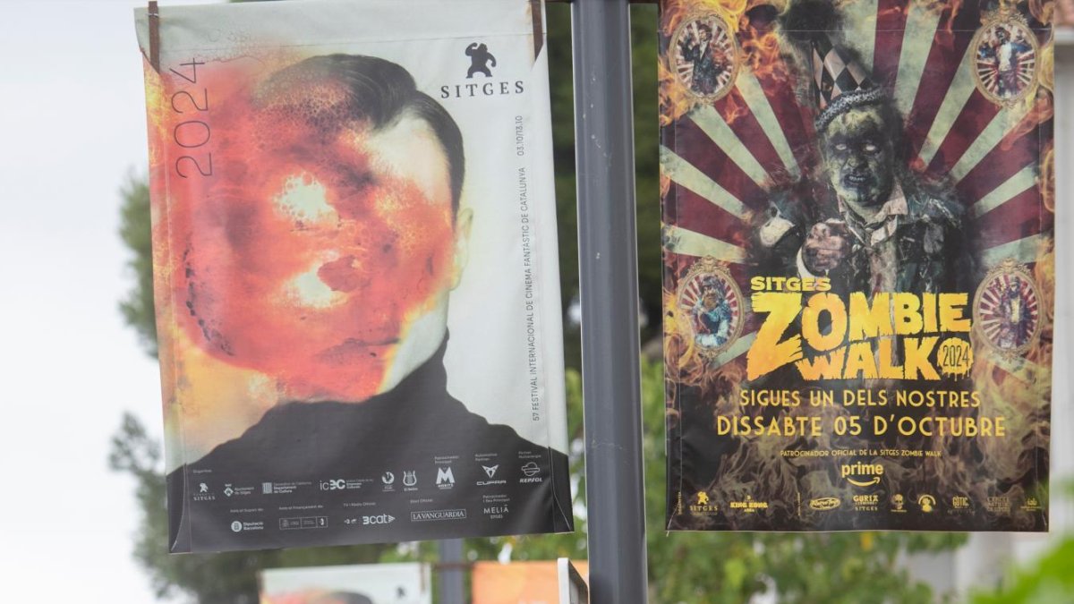 Carteles y viandantes en una de las calles que dan al Auditorio.